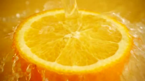 Mitad Una Naranja Chorro Agua Sobre Fondo Naranja Movimiento Lento — Vídeos de Stock