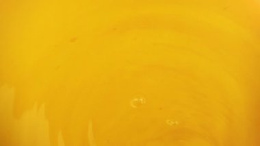 Portakal dilimleri turuncu arka planda suya düşer. Yavaş çekim.