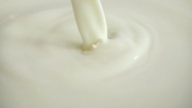 Sütlü yüzeye akan bir süt akışı. Yavaş çekim.