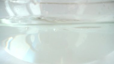 Cam bir kase suya düşen tatlı kırmızı biber. Yavaş çekim.