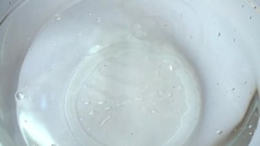 Portakal, limon ve elmayı cam bir kase suya döküyorum. Yavaş çekim.