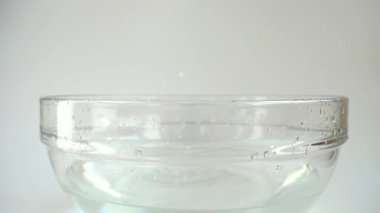 Falling cabbage Brassica oleracea into a glass bowl of water. Slow motion.