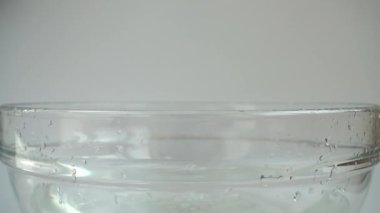 Falling cabbage Brassica oleracea into a glass bowl of water. Slow motion.