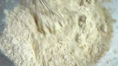 The process of making dough from flour, milk and eggs.