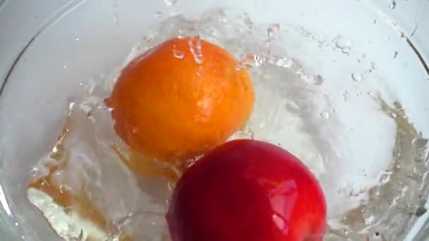 オレンジ レモン リンゴをコップ一杯の水に落とす スローモーション — ストック動画