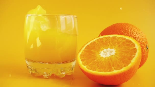 Portakal Suyuyla Bardağa Düşen Buz Küpleri Yavaş Çekim — Stok video