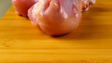 Taze tavuk bacakları kesme tahtasının üzerine serilmiştir..