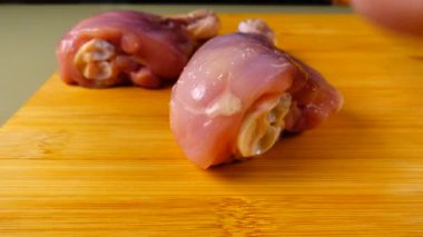 Taze tavuk bacakları kesme tahtasının üzerine serilmiştir..