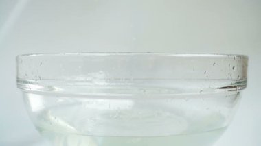 Falling cabbage Brassica oleracea into a glass bowl of water. Slow motion.