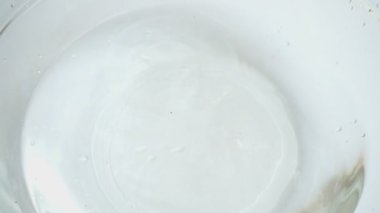 Cam bir kase suya düşen elmalar. Yavaş çekim.