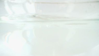 Cam bir kase suya düşen tatlı kırmızı biber. Yavaş çekim.