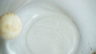 Cam bir kase suya düşen Agaricus mantarları. Yavaş çekim.