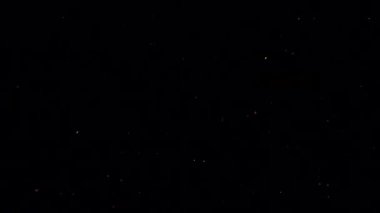 Siyah arka planda düşen patlamış mısır taneleri.