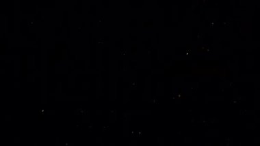 Siyah arka planda düşen patlamış mısır taneleri.