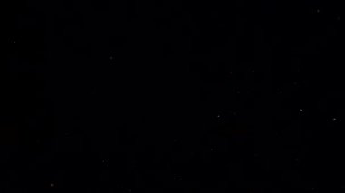 Siyah arka planda düşen patlamış mısır taneleri.