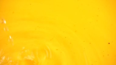 Turuncu arka planda suya çilek düşmesi. Yavaş çekim.