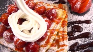 Çilekli Belçika waffleları, tatlı çilek soslu, krem şantili ve pudra şekerli beyaz arka planda bir taş tahtada.