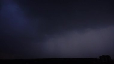 Gece gökyüzünde şimşek çakıyor şehrin üzerinde.