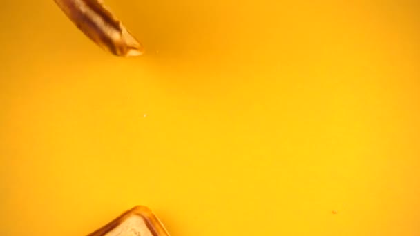 比利时华夫饼掉在黄色的背景上了 慢动作 — 图库视频影像