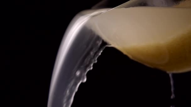 米を洗うと 黒い背景にボウルから水が注ぐ スローモーション — ストック動画