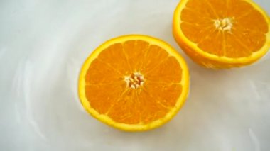 Beyaz arka planda olgun ve sulu portakallı suların dönüşümlü bölümleri. Yavaş çekim.