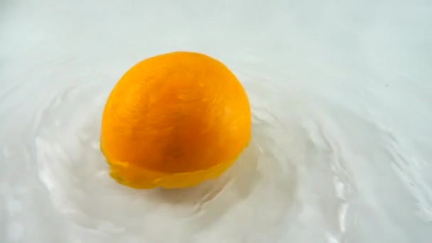 Draaiend Rijp Oranje Water Een Witte Achtergrond Langzame Beweging — Stockvideo