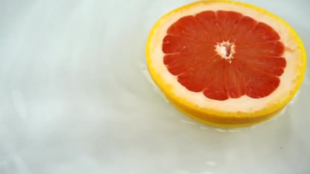 Rotierendes Segment Aus Reifen Und Saftigen Grapefruits Wasser Auf Weißem — Stockvideo