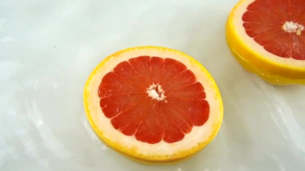 Rotierende Segmente Reifer Und Saftiger Grapefruit Wasser Auf Weißem Hintergrund — Stockvideo