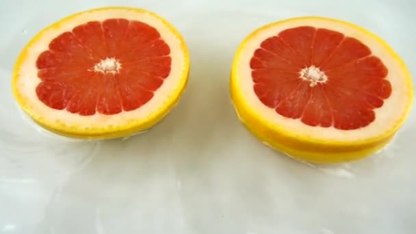 Forgó Szegmensek Érett Lédús Grapefruit Vízben Fehér Alapon Lassú Mozgás — Stock videók