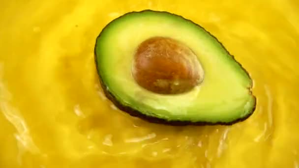 Roterend Segment Van Een Rijpe Sappige Avocado Een Oranje Achtergrond — Stockvideo