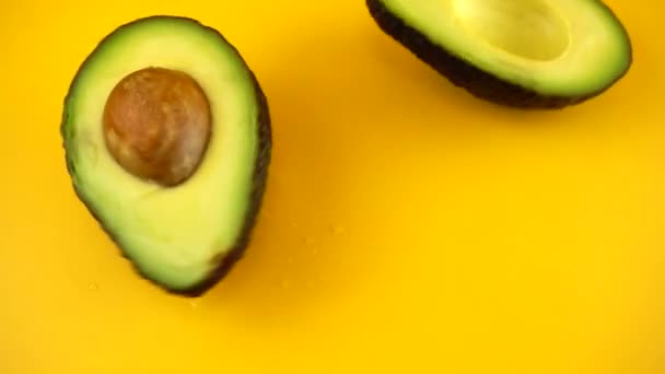 Roterende Segmenten Van Een Rijpe Sappige Avocado Een Oranje Achtergrond — Stockvideo