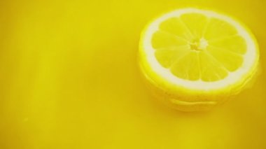 Turuncu arka planda olgun ve sulu bir limonun dönüşümlü bölümleri. Yavaş çekim.