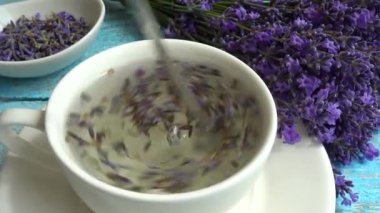 Eski ahşap arka planda taze lavanta çiçeklerinin çayı. Çay sıcak suda demlenir..
