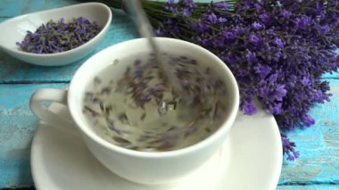Eski ahşap arka planda taze lavanta çiçeklerinin çayı. Çay sıcak suda demlenir..