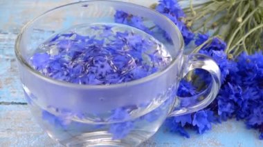 Brewing a tisanes from knapweeds flowers in a transparent cup.