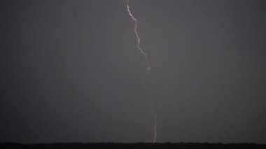 Gökgürültüsü bulutlarının arkaplanındaki şimşek.