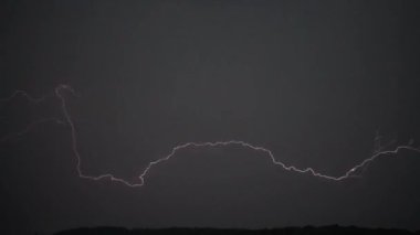 Gökgürültüsü bulutlarının arkaplanındaki şimşek.