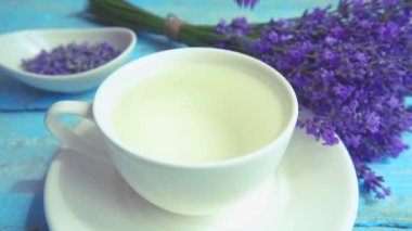 Eski ahşap arka planda taze lavanta çiçeklerinin çayı. Lavanta yaprakları ile düşen dallar. Yavaş çekim.