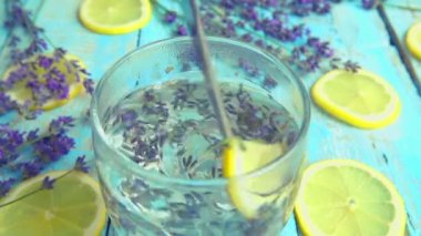 Taze lavanta çiçeklerinden limonata, ahşap bir arka planda limon. Yavaş çekim.
