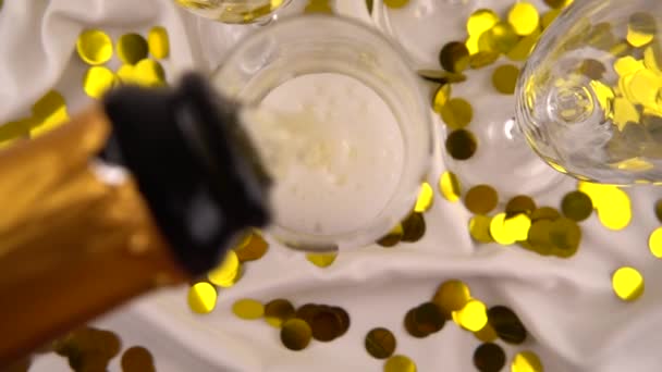 Pouring Bottle Sparkling Wine Glasses Background Confetti Slow Motion — Vídeos de Stock