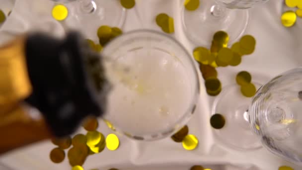 Pouring Bottle Sparkling Wine Glasses Background Confetti Slow Motion — Αρχείο Βίντεο