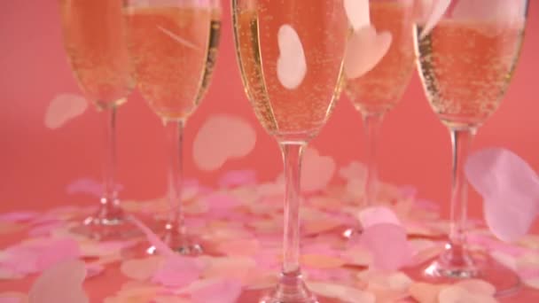 Falling Confetti Form Hearts Background Glasses Sparkling Wine Pink Background — ストック動画