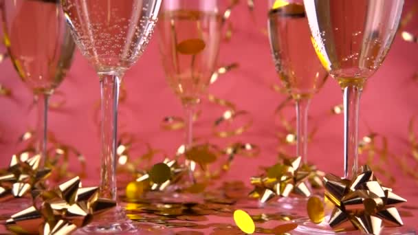 Falling Confetti Glasses Sparkling Wine Pink Background Serpentine Slow Motion — Vídeo de stock