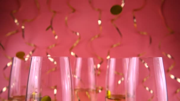Falling Confetti Glasses Sparkling Wine Pink Background Serpentine Slow Motion — 图库视频影像