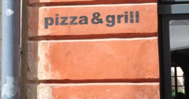 Elements of the ancient architecture of a European city. The inscription on the wall of the house craft beer and pizza and grill.