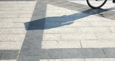 Riding a bicycle and an electric scooter on a tiled surface in the city.