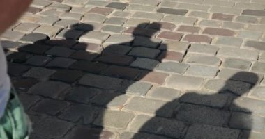 People crossing the street at a pedestrian crossing in summer.