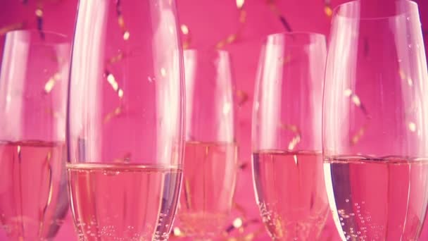 Glasses Sparkling Wine Background Falling Confetti Serpentine Pink Background Slow — ストック動画