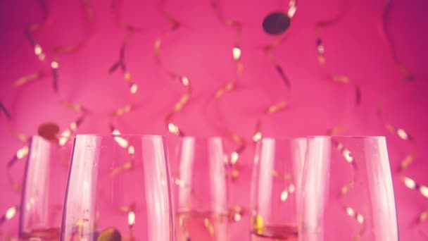 Falling Confetti Glasses Sparkling Wine Pink Background Serpentine Slow Motion — Video Stock