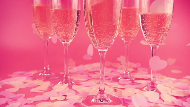Glasses Sparkling Wine Pink Background Falling Confetti Form Hearts Slow — Vídeo de stock